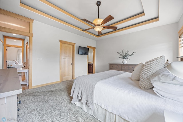 405 12th St NE, Dilworth, MN 56529 - carpeted bedroom with a tray ceiling, ensuite bath, baseboards, and ceiling fan