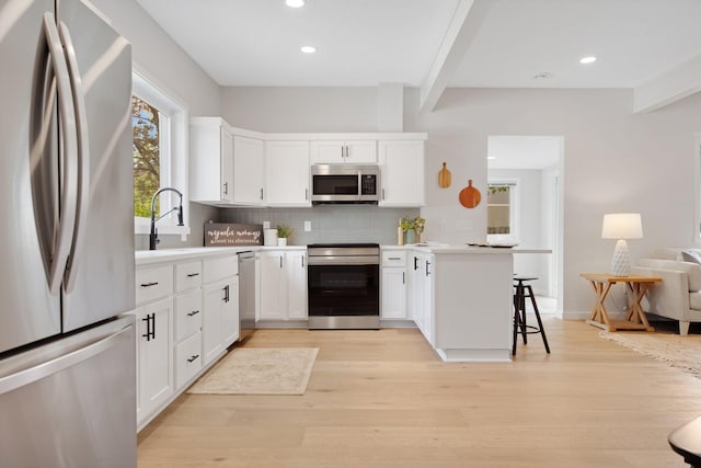 309 Shore Dr, Forest Lake, MN 55025 - kitchen featuring stainless steel appliances, light wood-type flooring, beam ceiling, backsplash, and recessed lighting