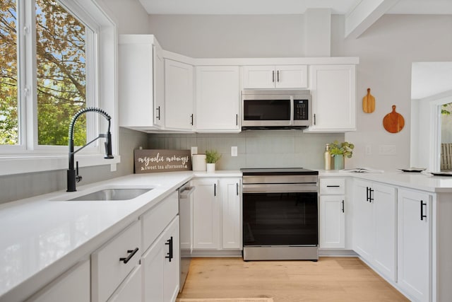 309 Shore Dr, Forest Lake, MN 55025 - kitchen with appliances with stainless steel finishes, a sink, backsplash, and healthy amount of natural light
