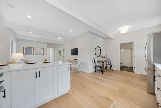 309 Shore Dr, Forest Lake, MN 55025 - kitchen with freestanding refrigerator, light wood-style floors, light countertops, white cabinets, and beam ceiling