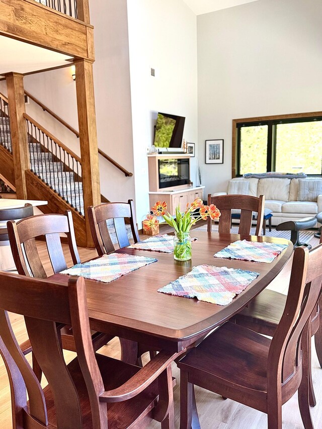 30710 County Road 45, Marcell Twp, MN 56628 - dining area with stairs, a high ceiling, and wood finished floors
