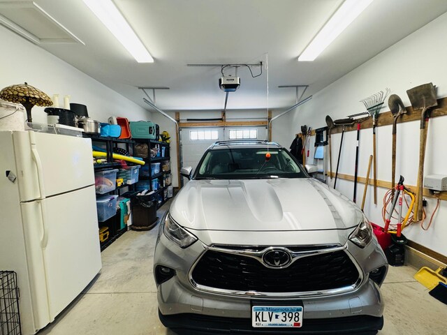 30710 County Road 45, Marcell Twp, MN 56628 - garage featuring freestanding refrigerator and a garage door opener