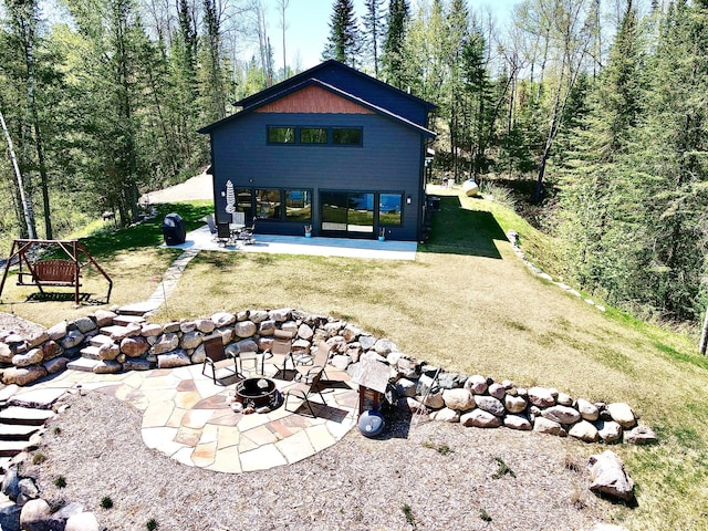 30710 County Road 45, Marcell Twp, MN 56628 - rear view of house featuring a fire pit, a patio, and a lawn