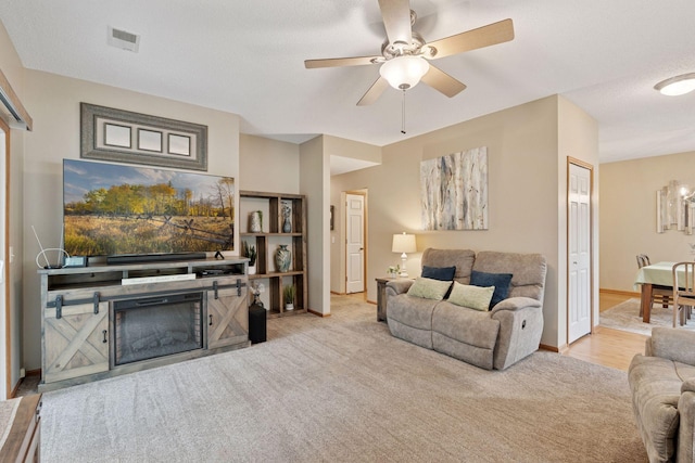 13900 Garnet Ter NW, Ramsey, MN 55303 - carpeted living room with ceiling fan and a glass covered fireplace