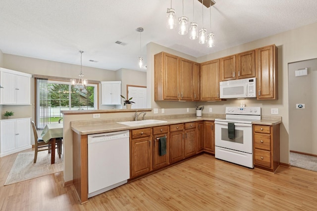 13900 Garnet Ter NW, Ramsey, MN 55303 - kitchen with white appliances, light wood-style flooring, light countertops, hanging light fixtures, and a chandelier