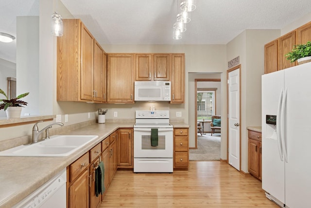 13900 Garnet Ter NW, Ramsey, MN 55303 - kitchen featuring white appliances, light wood-style floors, light countertops, and a textured ceiling