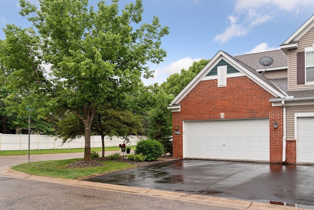 13900 Garnet Ter NW, Ramsey, MN 55303 - view of property exterior with brick siding, roof with shingles, asphalt driveway, and a garage