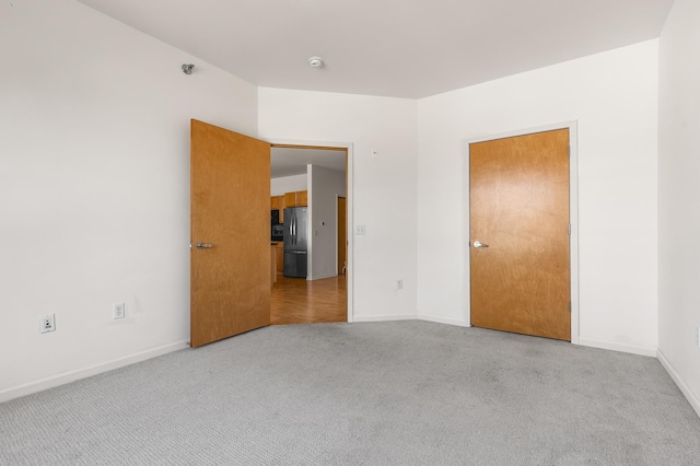 unfurnished room featuring carpet flooring and baseboards