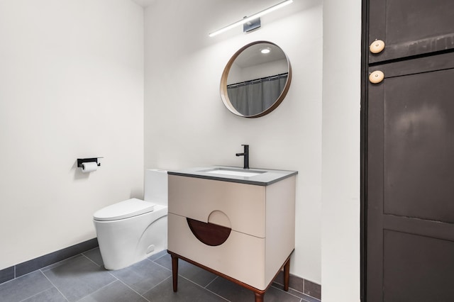 full bathroom with baseboards, vanity, tile patterned flooring, and toilet