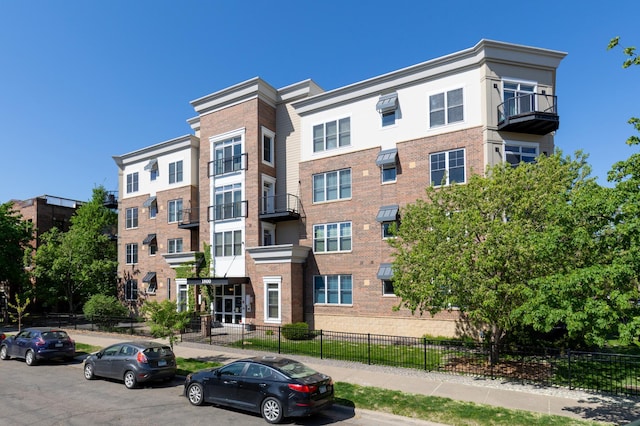view of apartment building / complex featuring fence