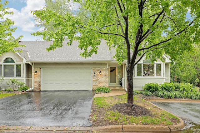 8207 Norman Creek Trl, Bloomington, MN 55437 - view of front of house featuring brick siding, a garage, concrete driveway, and roof with shingles