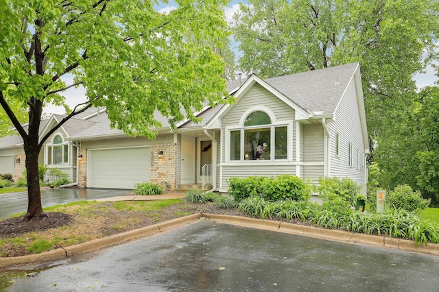 8207 Norman Creek Trl, Bloomington, MN 55437 - ranch-style house featuring a garage, brick siding, a shingled roof, and driveway