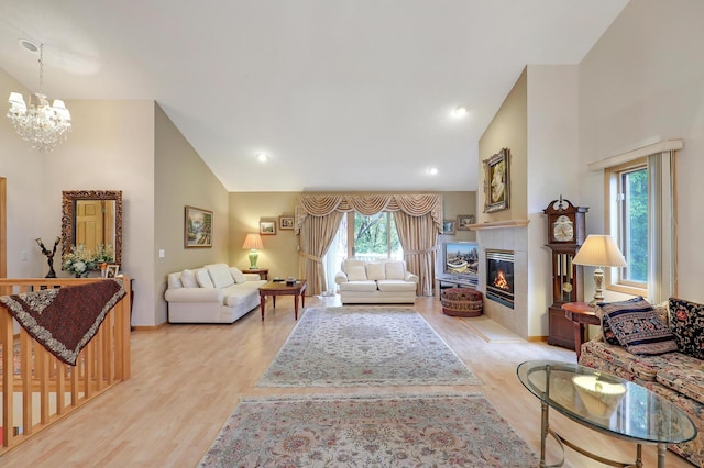 8207 Norman Creek Trl, Bloomington, MN 55437 - living room featuring wood finished floors, a chandelier, a tile fireplace, high vaulted ceiling, and baseboards