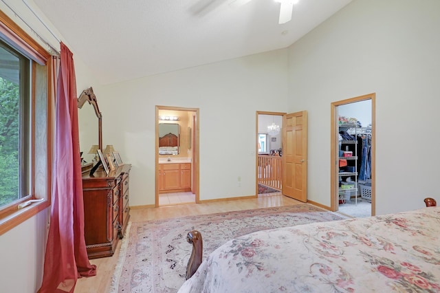 8207 Norman Creek Trl, Bloomington, MN 55437 - bedroom featuring a walk in closet, ensuite bathroom, light wood-type flooring, baseboards, and high vaulted ceiling