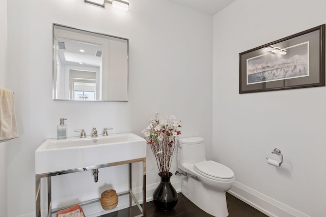 1111 River Pkwy Unit 24C, Minneapolis, MN 55415 - half bathroom featuring toilet, baseboards, and wood finished floors