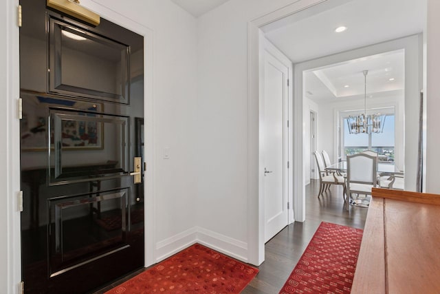 1111 River Pkwy Unit 24C, Minneapolis, MN 55415 - hallway featuring dark wood-style floors, a chandelier, recessed lighting, and a raised ceiling