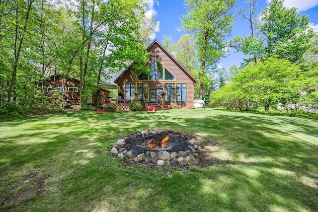 209 9 1/2 Ave, Turtle Lake, WI 54889 - rear view of property featuring a fire pit, a wooden deck, and a lawn