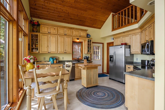209 9 1/2 Ave, Turtle Lake, WI 54889 - kitchen featuring appliances with stainless steel finishes, a sink, a kitchen island, light tile patterned flooring, and glass insert cabinets