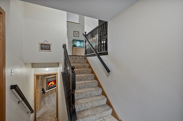604 Brookview Ln SW, Isanti, MN 55040 - stairs featuring a fireplace and a textured ceiling