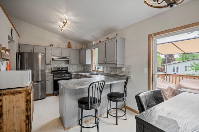 604 Brookview Ln SW, Isanti, MN 55040 - kitchen featuring stainless steel range with gas cooktop, gray cabinetry, under cabinet range hood, white microwave, and a peninsula