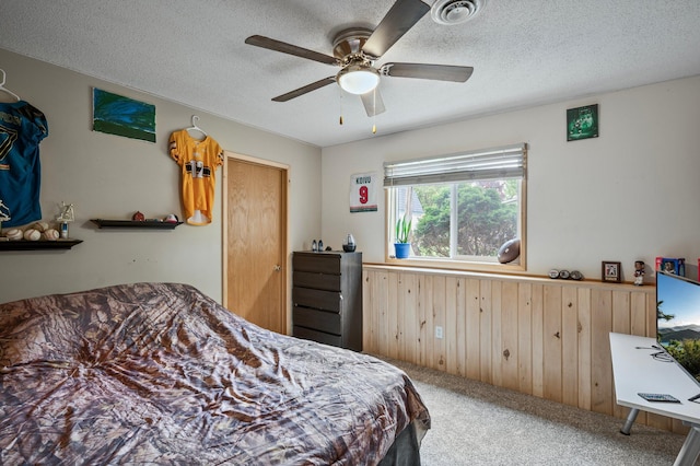 604 Brookview Ln SW, Isanti, MN 55040 - carpeted bedroom with a textured ceiling, wood walls, and a ceiling fan