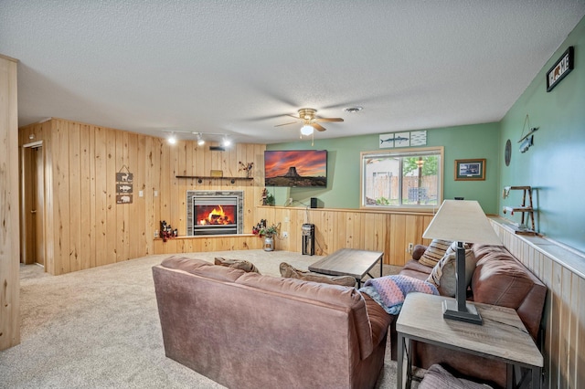 604 Brookview Ln SW, Isanti, MN 55040 - living room with wooden walls, carpet flooring, ceiling fan, a tiled fireplace, and a textured ceiling