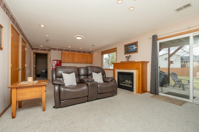 living room featuring light carpet, baseboards, recessed lighting, and a glass covered fireplace