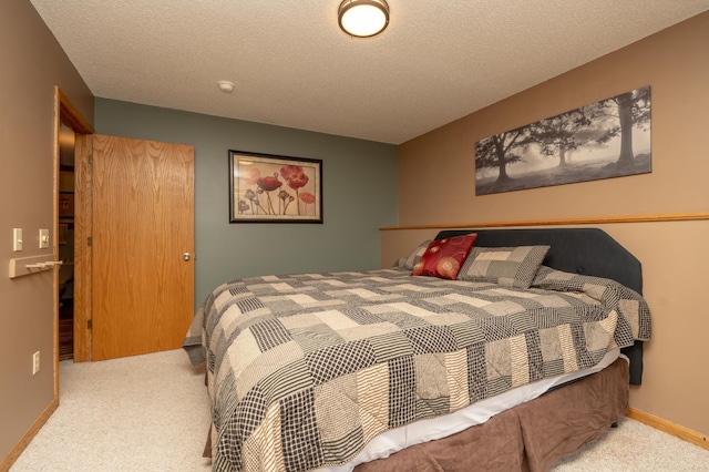 carpeted bedroom featuring a textured ceiling and baseboards