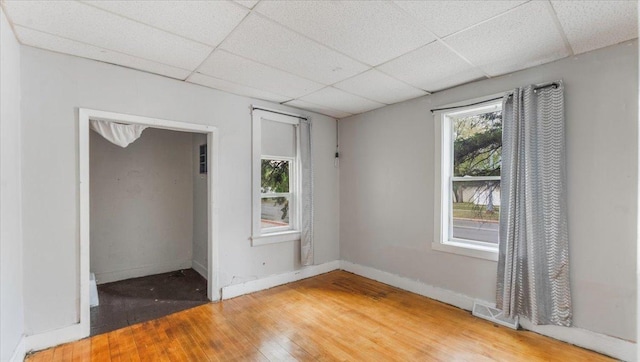 1001 Washington Memorial Dr, Saint Cloud, MN 56301 - spare room with hardwood / wood-style floors, a paneled ceiling, and baseboards