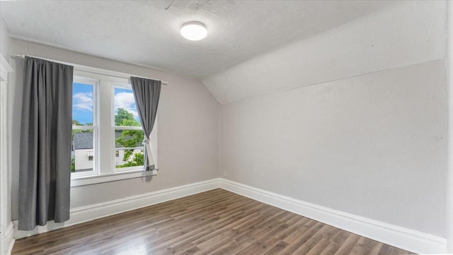1001 Washington Memorial Dr, Saint Cloud, MN 56301 - additional living space with baseboards, vaulted ceiling, dark wood-style flooring, and a textured ceiling