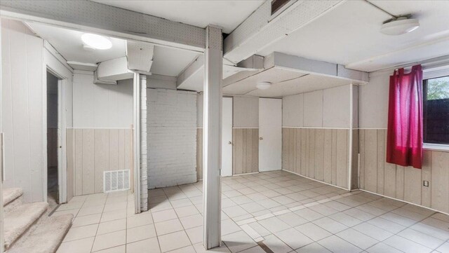 1001 Washington Memorial Dr, Saint Cloud, MN 56301 - basement featuring wooden walls, light tile patterned floors, and wainscoting
