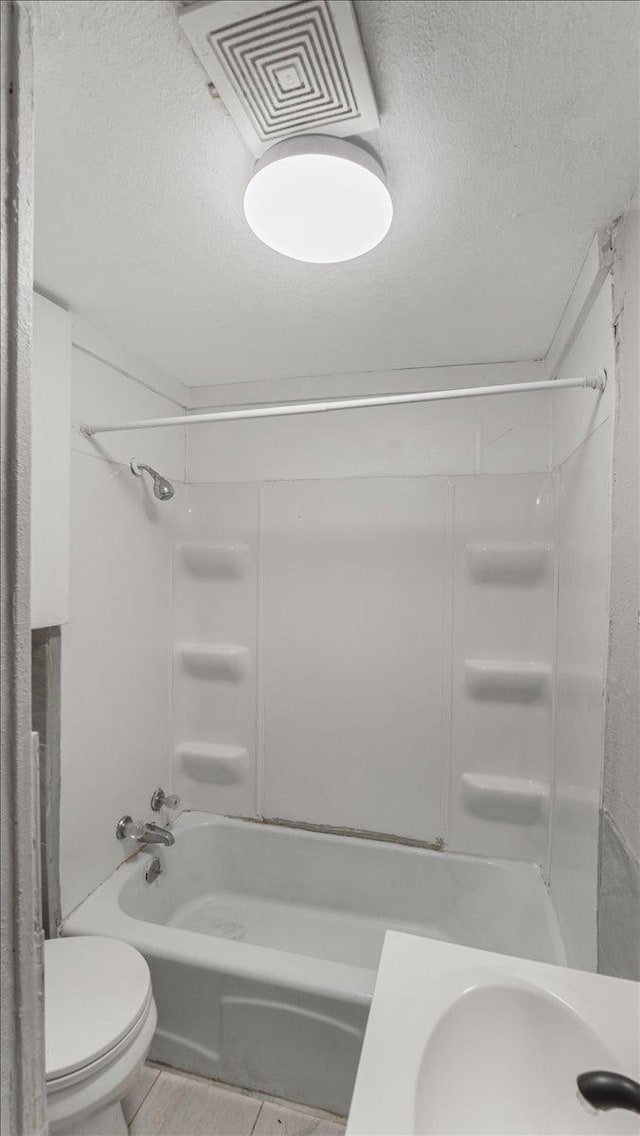1001 Washington Memorial Dr, Saint Cloud, MN 56301 - bathroom featuring toilet, a textured ceiling, tub / shower combination, a sink, and tile patterned flooring