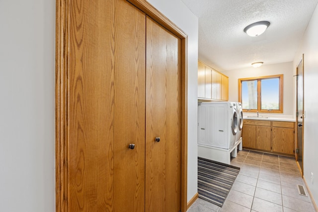 25306 Csah 4, Dassel Twp, MN 55325 - laundry area with cabinet space, washing machine and dryer, a textured ceiling, and light tile patterned floors