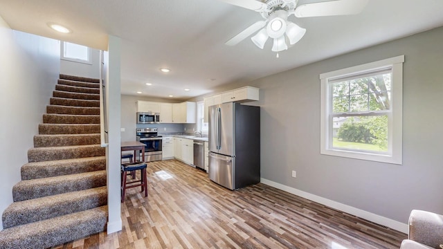 368 Main St, Zumbrota, MN 55992 - kitchen with stainless steel appliances, light wood-style floors, white cabinetry, baseboards, and light countertops