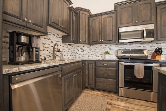 8259 Barton Ave NW, Buffalo, MN 55313 - kitchen featuring appliances with stainless steel finishes, dark brown cabinetry, and backsplash