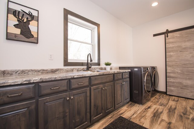 8259 Barton Ave NW, Buffalo, MN 55313 - laundry room with washing machine and clothes dryer, light wood finished floors, cabinet space, recessed lighting, and a barn door