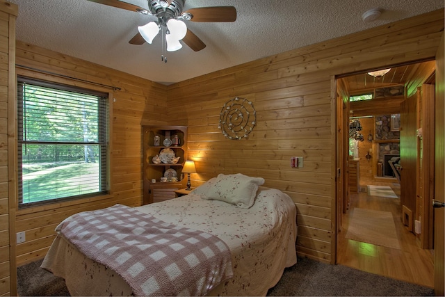 6000 152nd St, Milaca, MN 56353 - bedroom featuring wooden walls, a textured ceiling, and ceiling fan