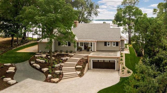 1397 Orono Ln, Orono, MN 55391 - view of front facade featuring decorative driveway, a water view, a garage, a chimney, and a front lawn
