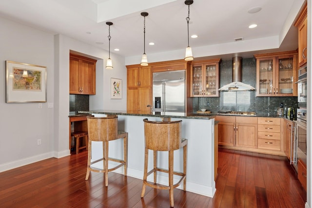 100 3rd Ave S Unit 3301, Minneapolis, MN 55401 - kitchen with appliances with stainless steel finishes, wall chimney exhaust hood, dark wood finished floors, backsplash, and recessed lighting