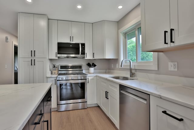 8466 Isleton Ct S, Cottage Grove, MN 55016 - kitchen featuring appliances with stainless steel finishes, a sink, white cabinetry, recessed lighting, and light stone countertops