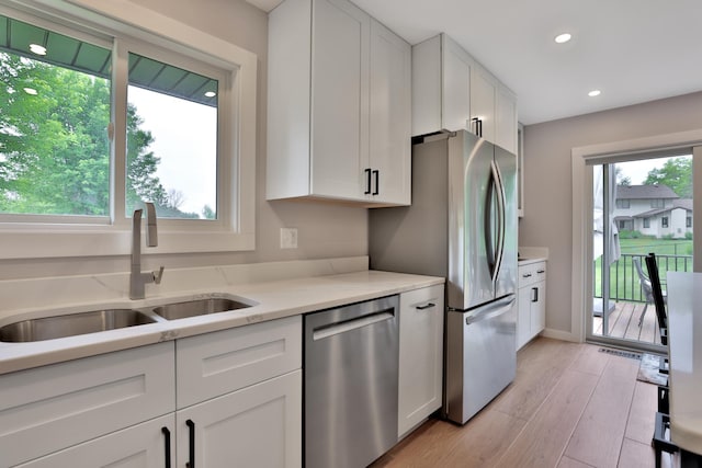 8466 Isleton Ct S, Cottage Grove, MN 55016 - kitchen with stainless steel appliances, a sink, white cabinets, recessed lighting, and light wood-type flooring