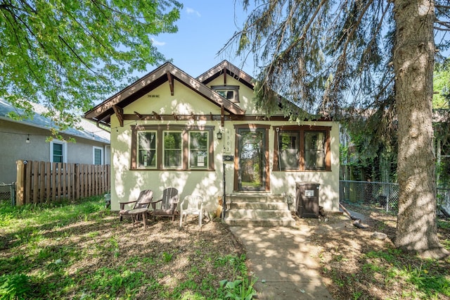 view of front of property featuring stucco siding, fence, and entry steps