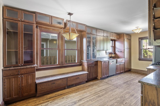 kitchen featuring dishwasher, light wood finished floors, pendant lighting, a sink, and baseboards