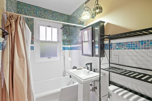 full bath with tile walls, shower / tub combo, and toilet