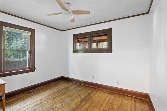 unfurnished room featuring baseboards, dark wood finished floors, ceiling fan, and ornamental molding
