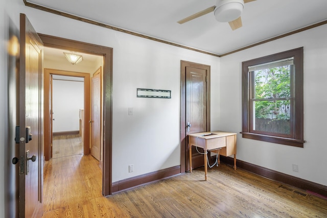 bedroom featuring light wood-style floors, crown molding, baseboards, and ceiling fan