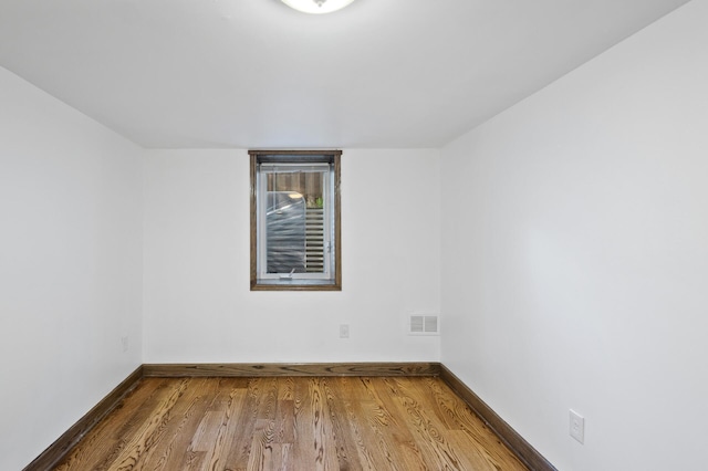 spare room featuring wood finished floors and baseboards