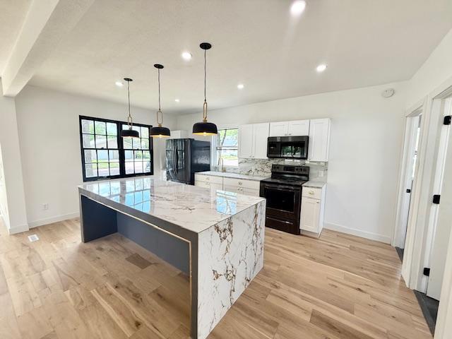 503 3rd St, Redwood Falls, MN 56283 - kitchen with black appliances, healthy amount of natural light, a kitchen island, baseboards, and recessed lighting