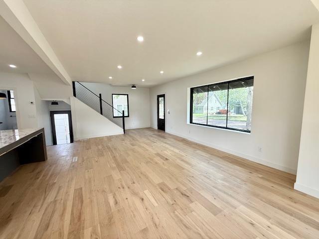 503 3rd St, Redwood Falls, MN 56283 - unfurnished living room featuring light wood finished floors, recessed lighting, stairway, and baseboards