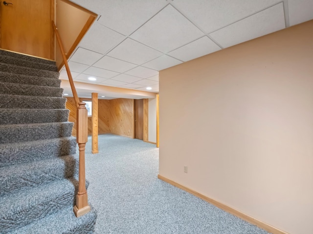 835 Winona Dr SW, Alexandria, MN 56308 - basement featuring carpet floors, stairs, baseboards, wooden walls, and a paneled ceiling